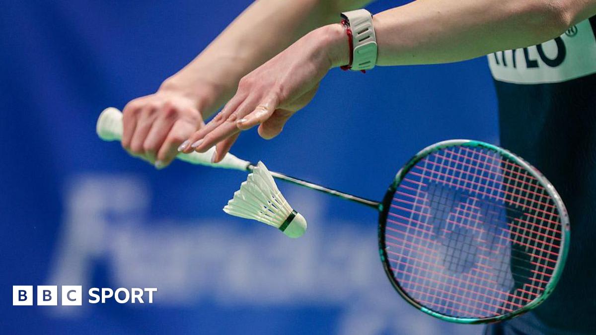 Traditional feathered badminton shuttlecocks arranged on court during international tournament play