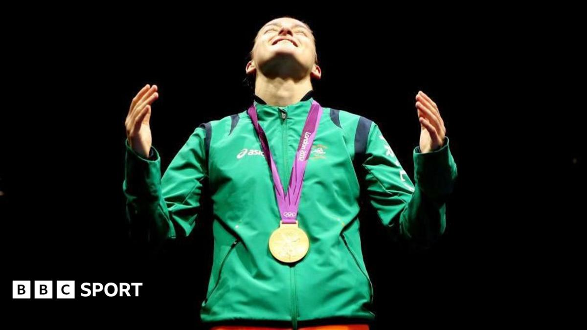 Katie Taylor laying her boxing gloves in the center of the Croke Park ring