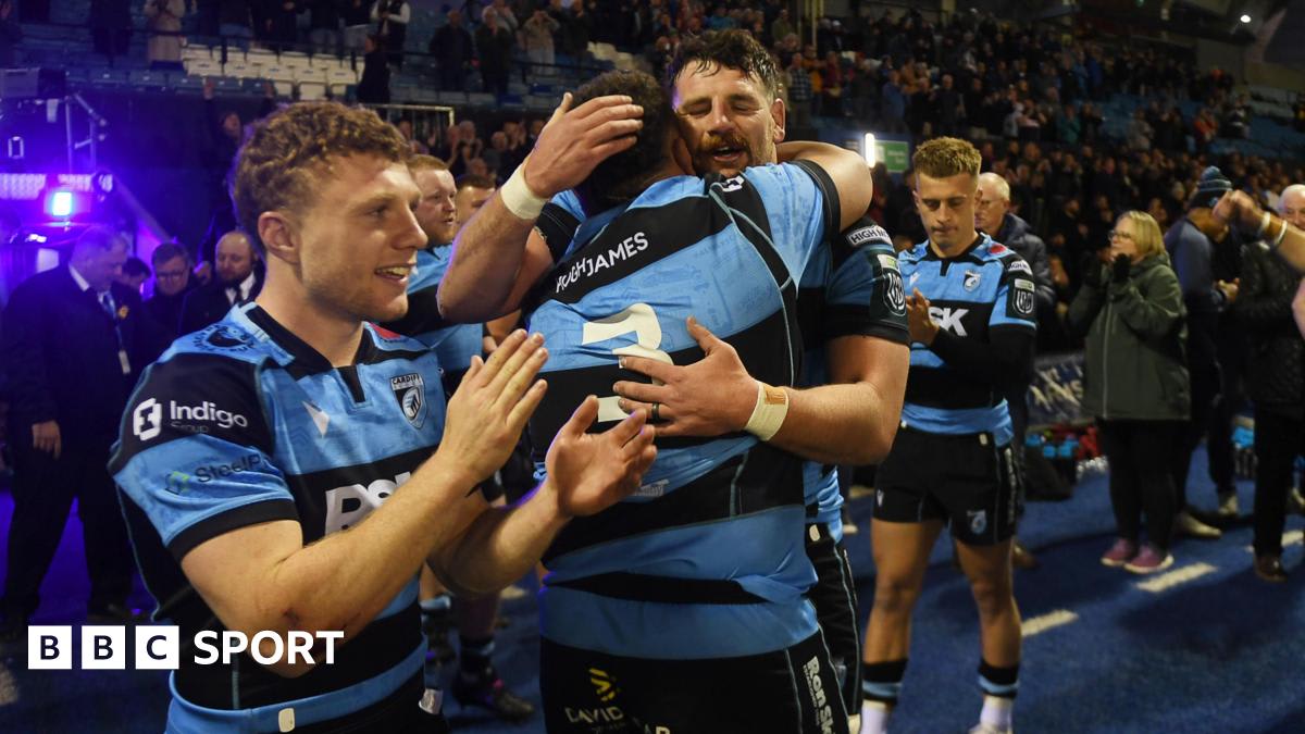 Cardiff rugby players celebrating on field at Arms Park stadium with cheering crowd
