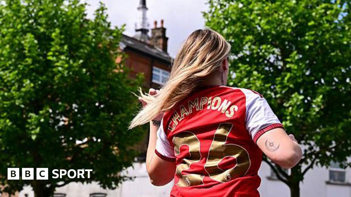 Arsenal fans celebrating in crowds outside Emirates Stadium after winning Premier League title
