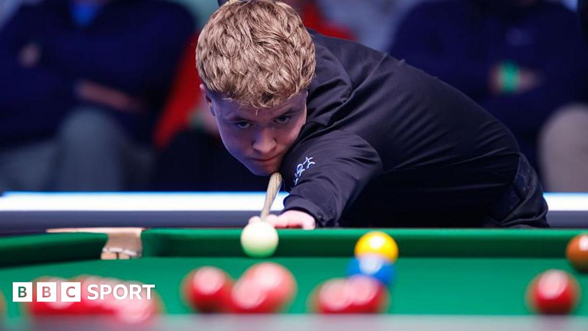 Young snooker player Stan Moody celebrating at table after winning qualifying match