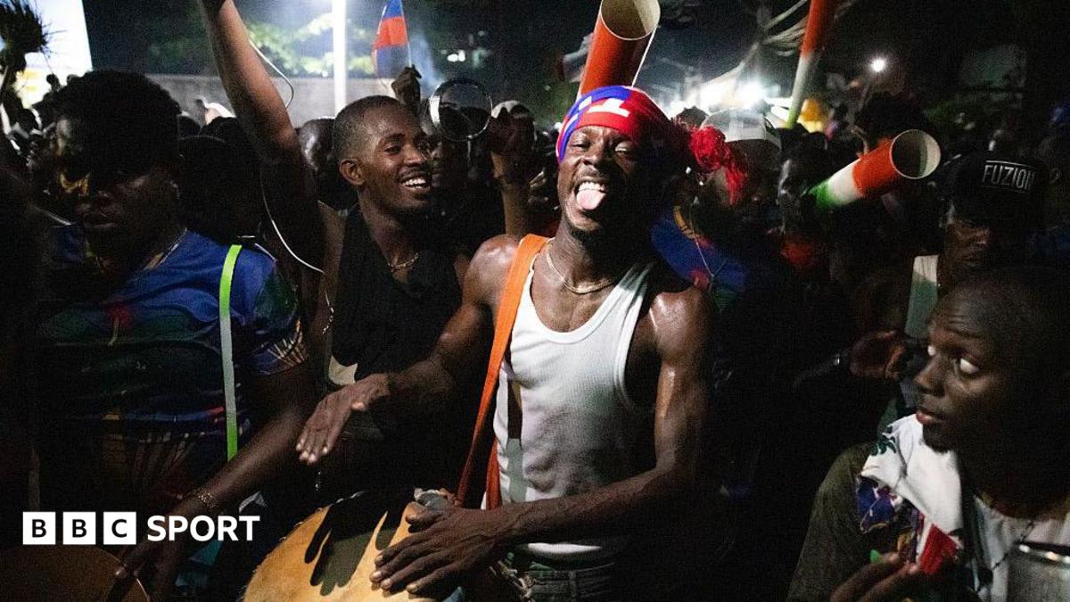 ** Haitian soccer fans waving flags and celebrating their national team's World Cup qualification