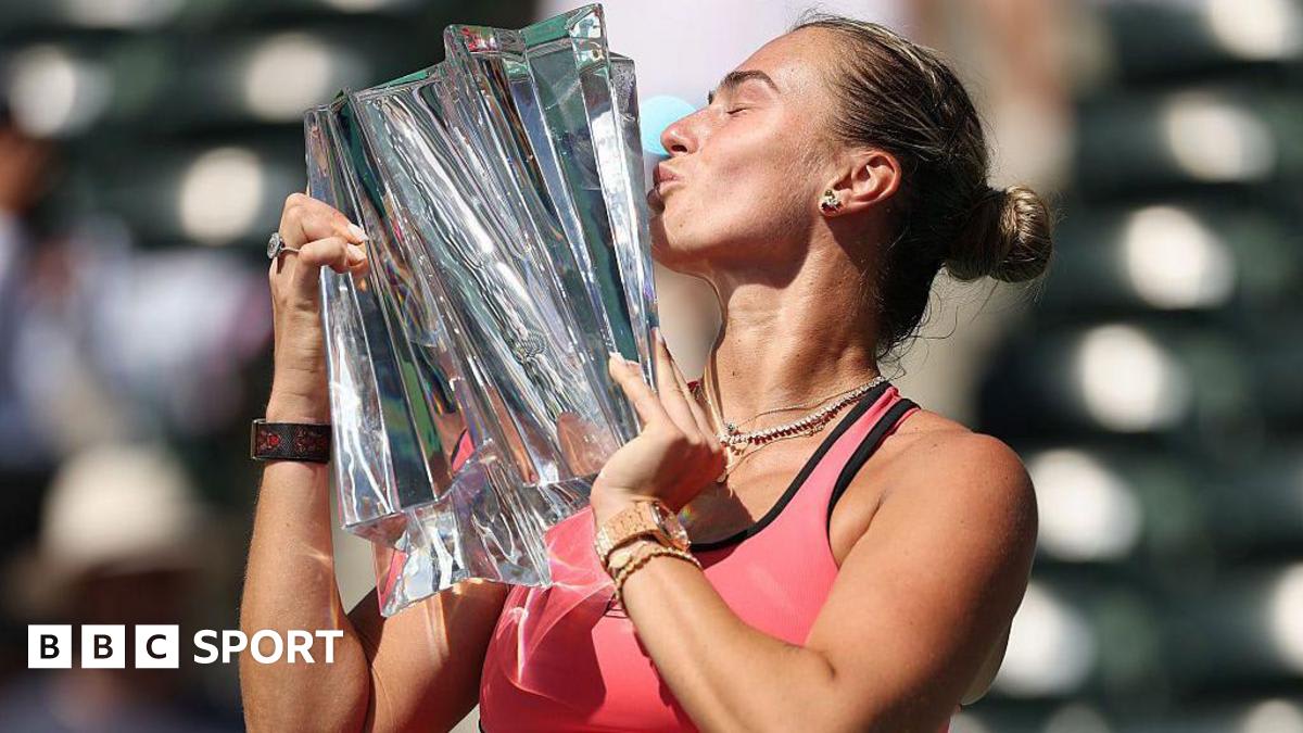 Aryna Sabalenka celebrates winning Indian Wells tennis championship with trophy raised overhead