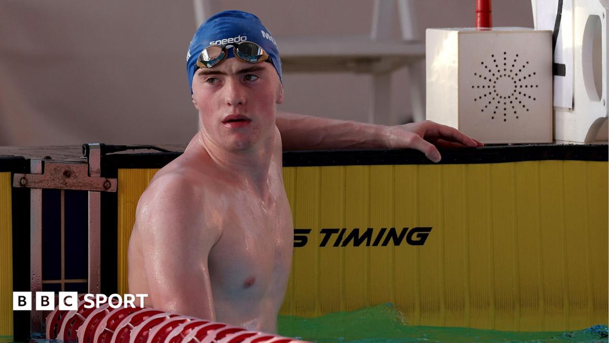 Young male swimmer Sean McCann in competitive swimming gear preparing for freestyle race