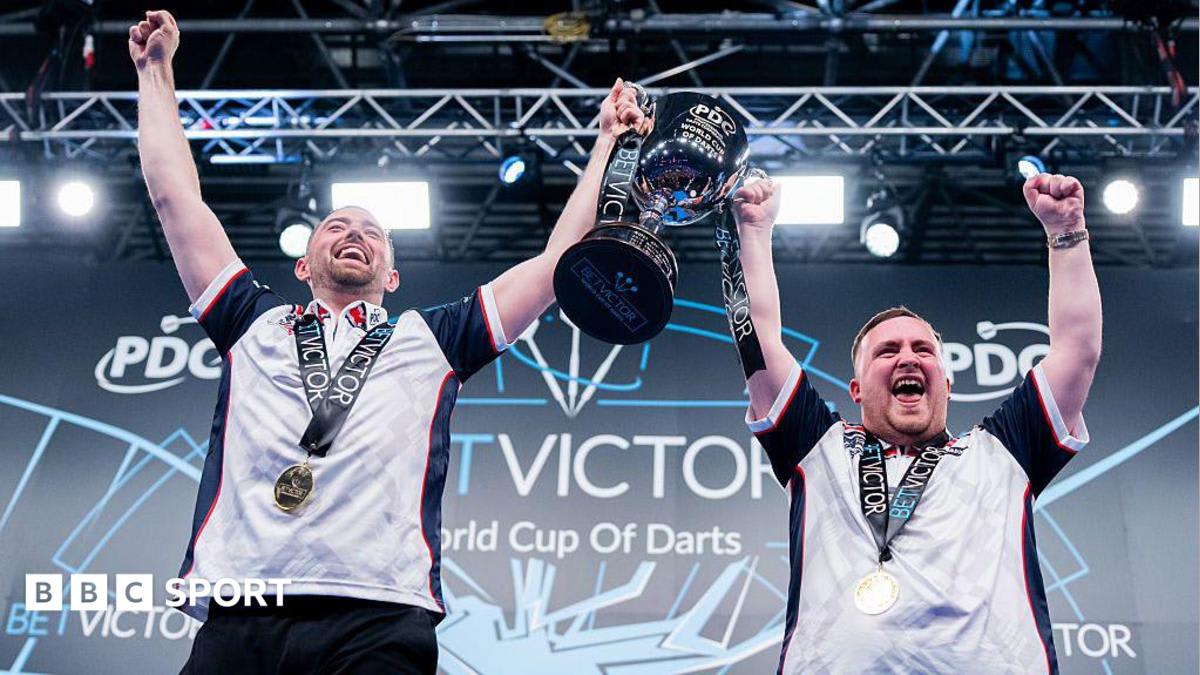 Luke Littler and Luke Humphries celebrating with England flag after World Cup of Darts victory