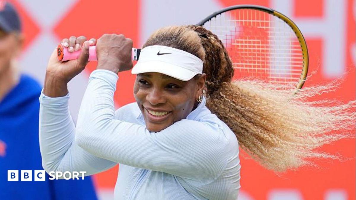 Serena Williams holding tennis racket on court during professional doubles match