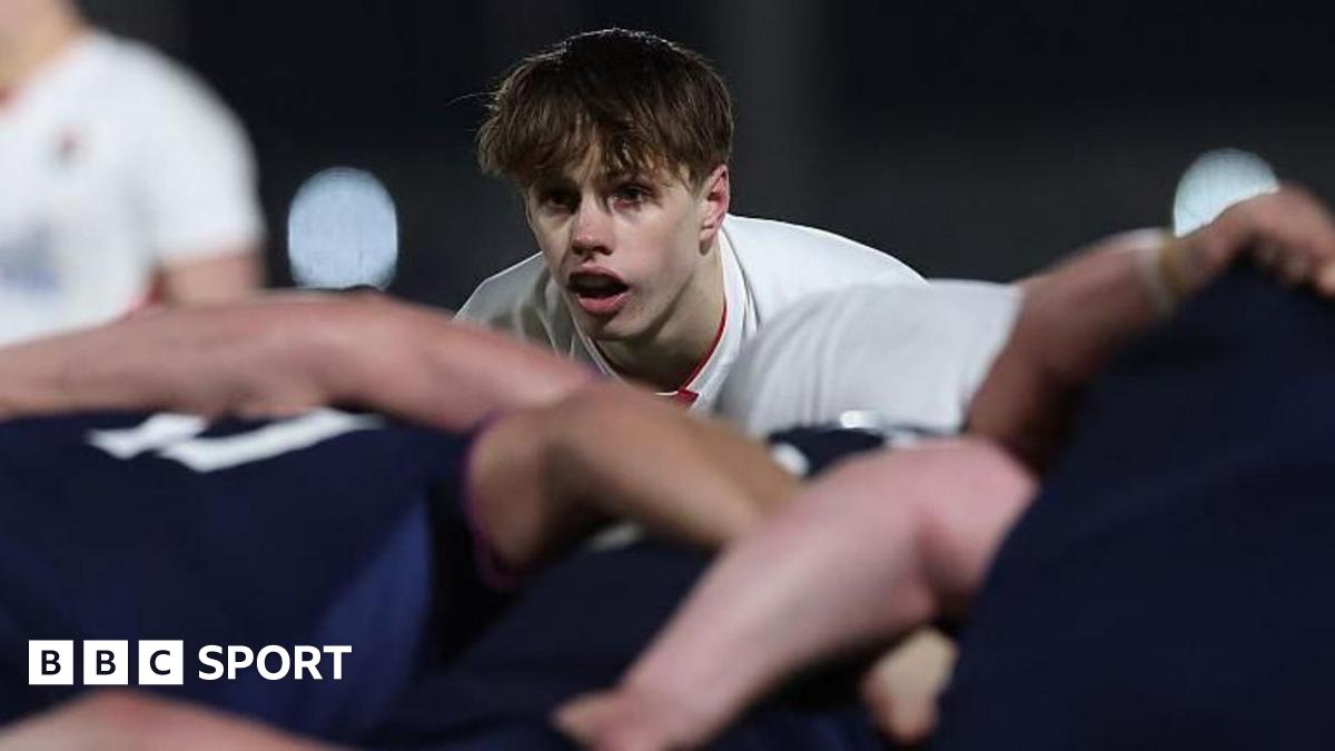 Young rugby player Lucas Friday in Harlequins jersey preparing to pass the ball during match