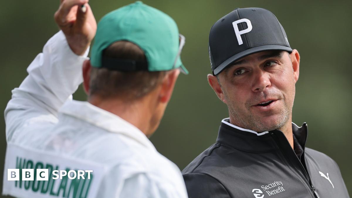 Professional golfer Gary Woodland walking on golf course with caddie and security team nearby