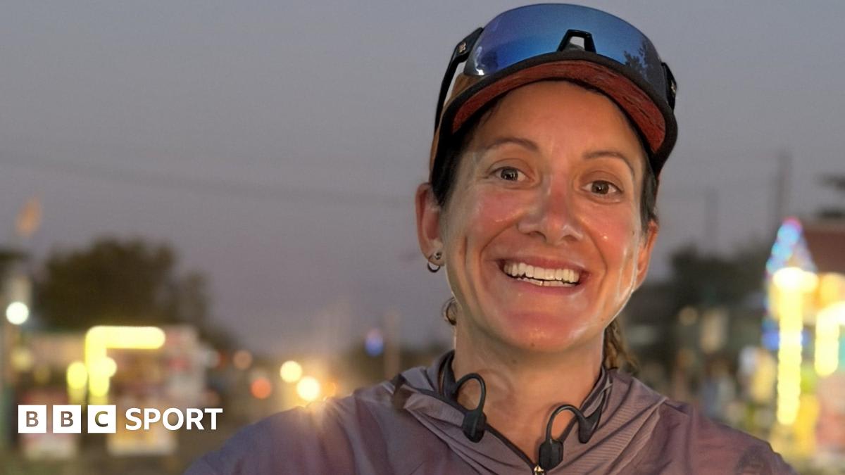 Hannah Cox running on dusty Indian road with colorful vehicles passing by
