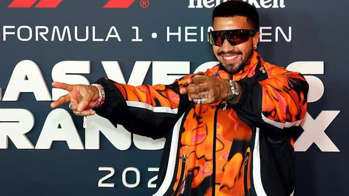 Olympic fencer Miles Chamley-Watson in white fencing uniform holding foil sword at competition