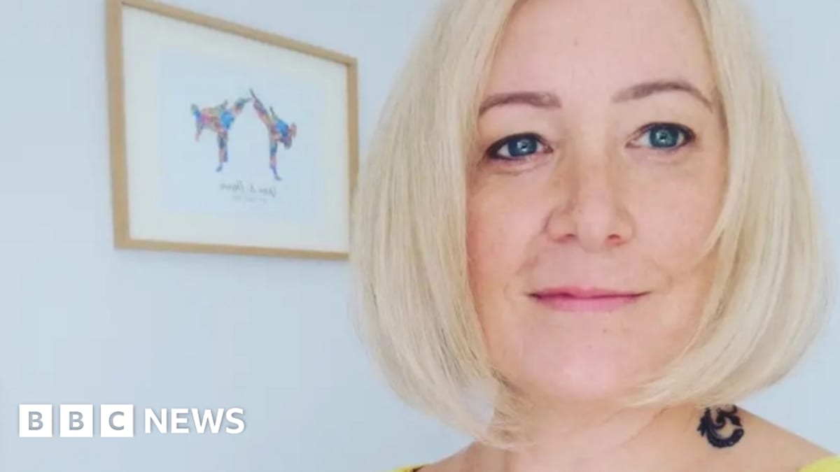 Woman holds NHS bowel cancer screening test kit that helped detect early stage cancer
