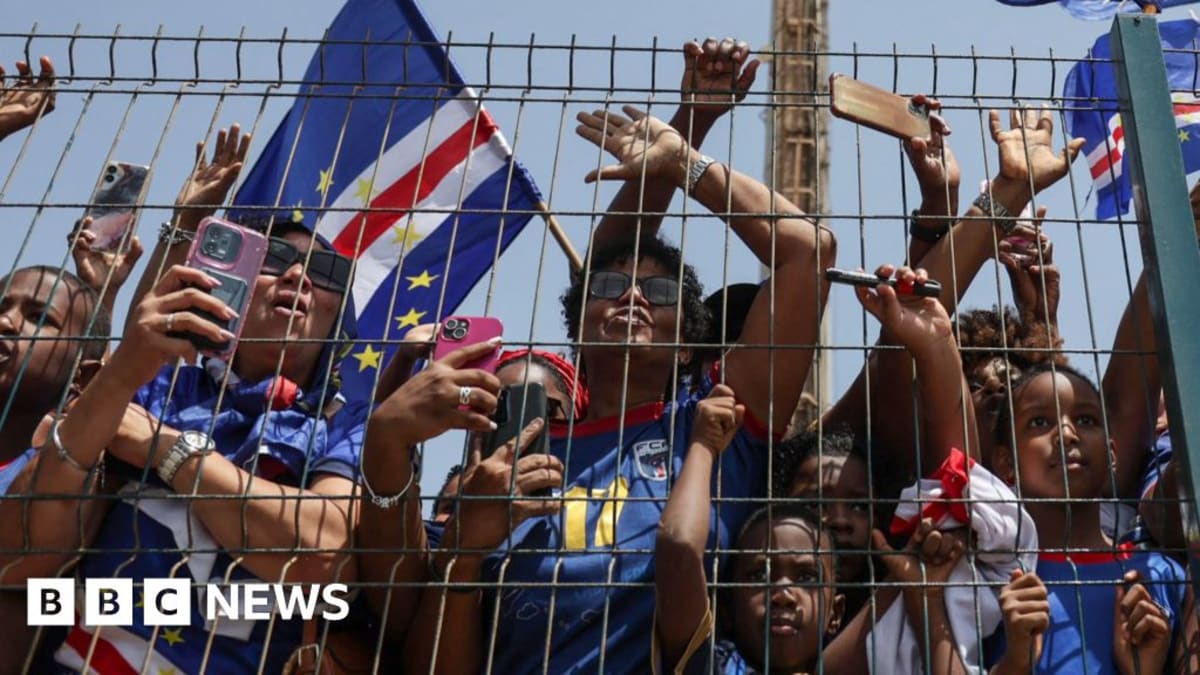 Thousands of Cape Verde fans in blue celebrating at Praia airport welcoming football team home