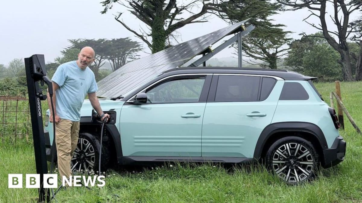 Solar-powered electric car being charged at British solar farm during cross-country journey