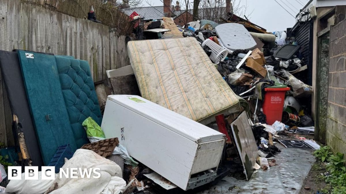 Workers cleaning up illegally dumped waste from a rural English roadside location