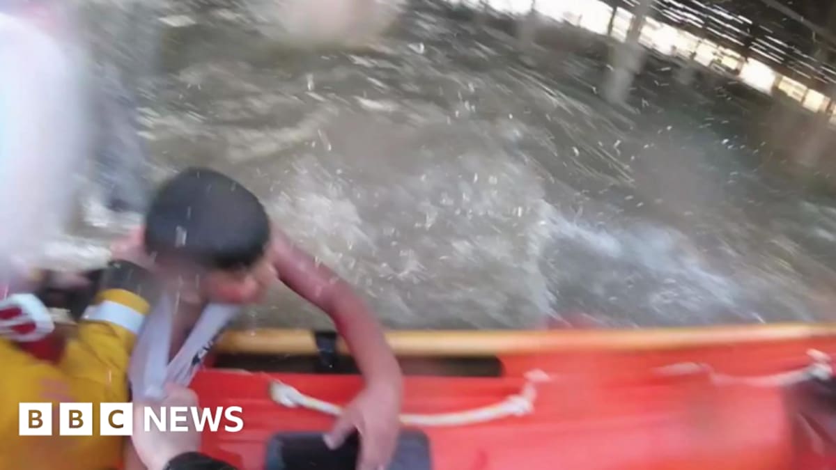 Young boy Subby hugging RNLI lifeboat volunteer after dramatic pier rescue in Blackpool
