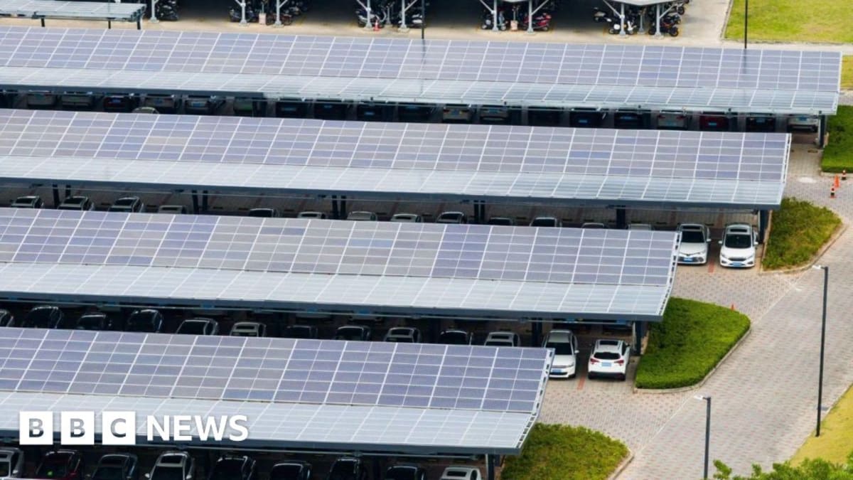 Solar panel canopies covering parking spaces at park and ride facility with electric vehicle charging stations
