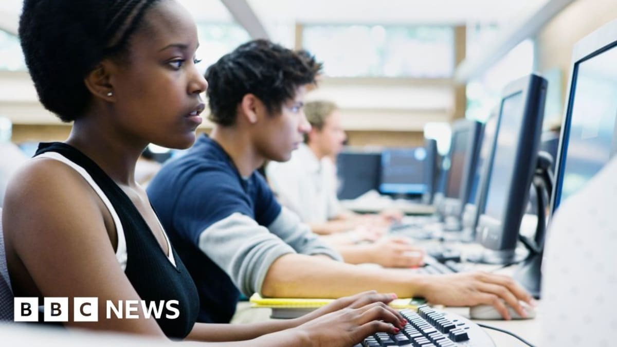 University students working on laptops in a lecture hall taking exams