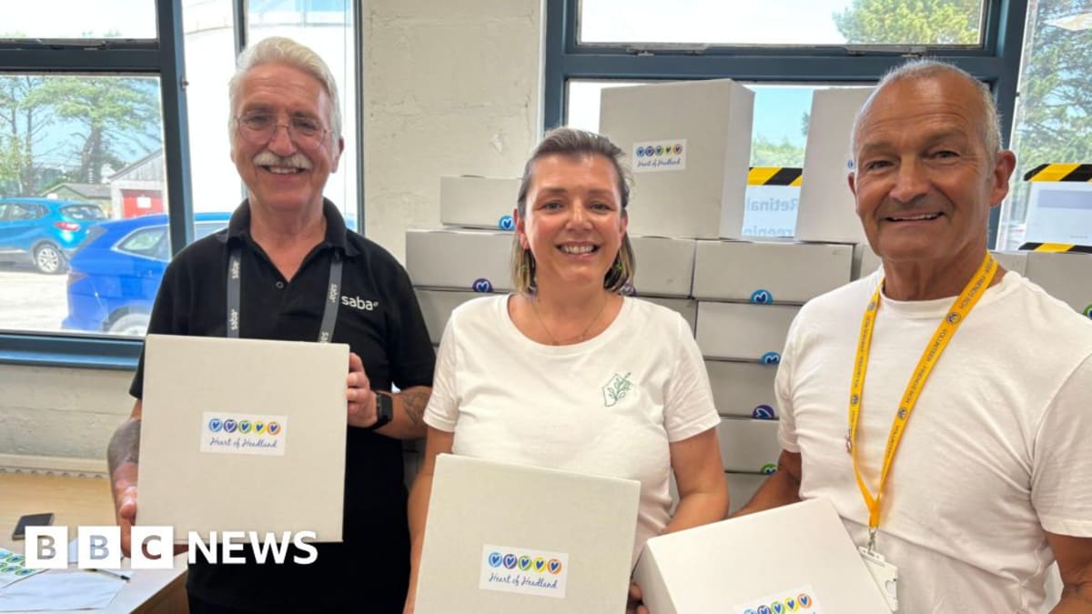 Volunteer Kelly Hallett smiling while packing care boxes filled with comfort items for cancer patients