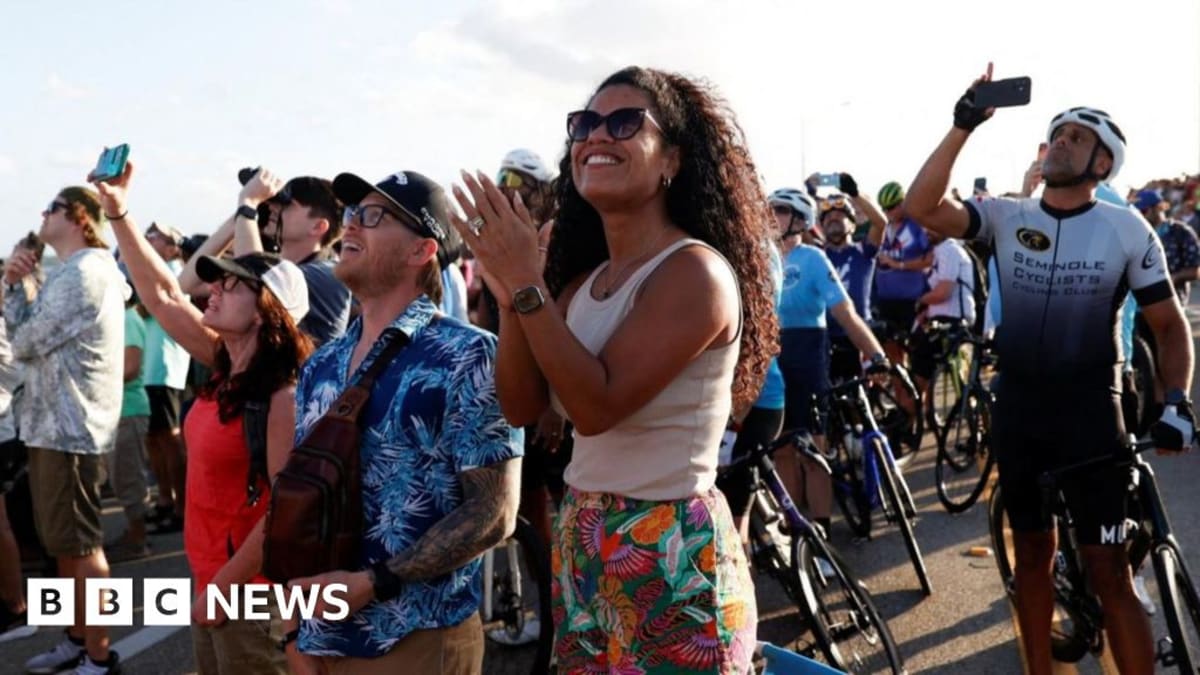 NASA's white Space Launch System rocket launching at dusk with brilliant flames and smoke