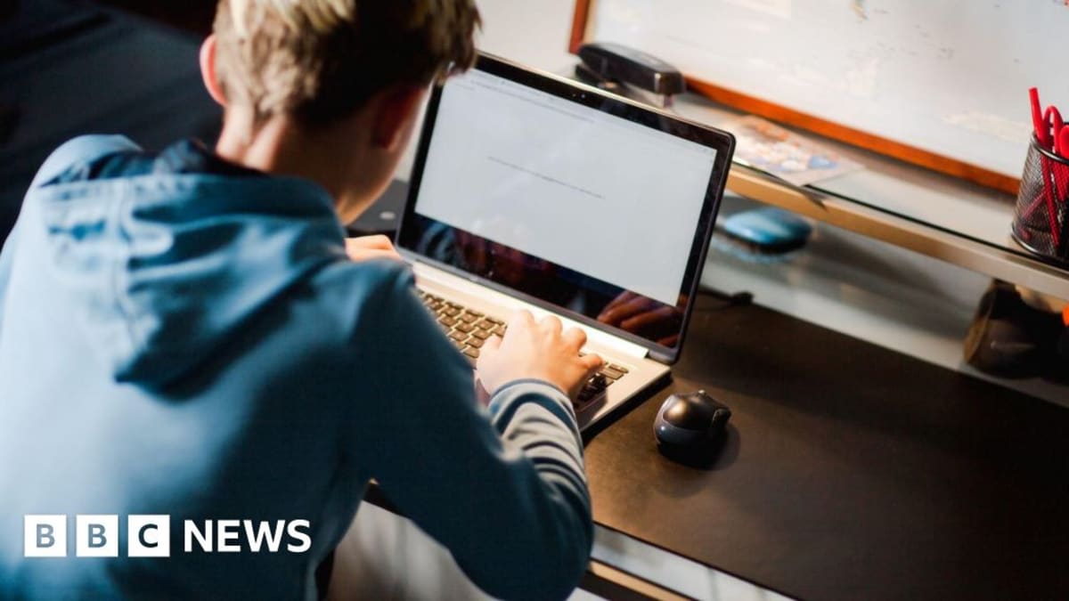 Police officer mentoring teenage boy at home computer discussing cybersecurity career opportunities