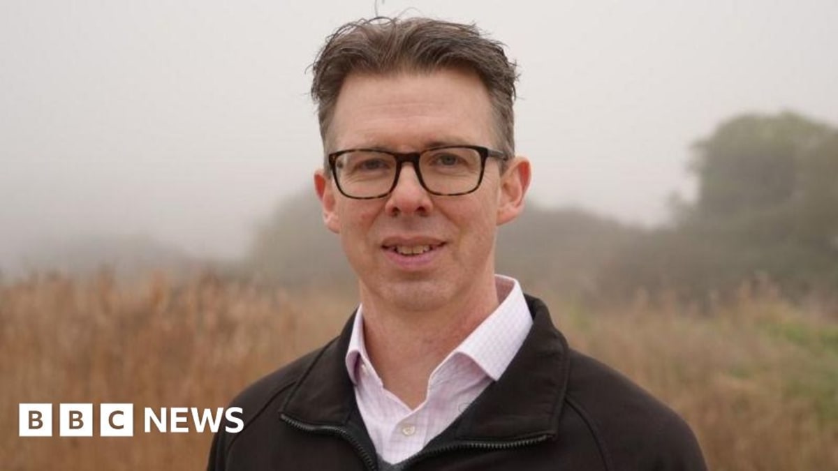Eliot Lyne standing on open farmland at Wood Norton future wildlife reserve site Norfolk