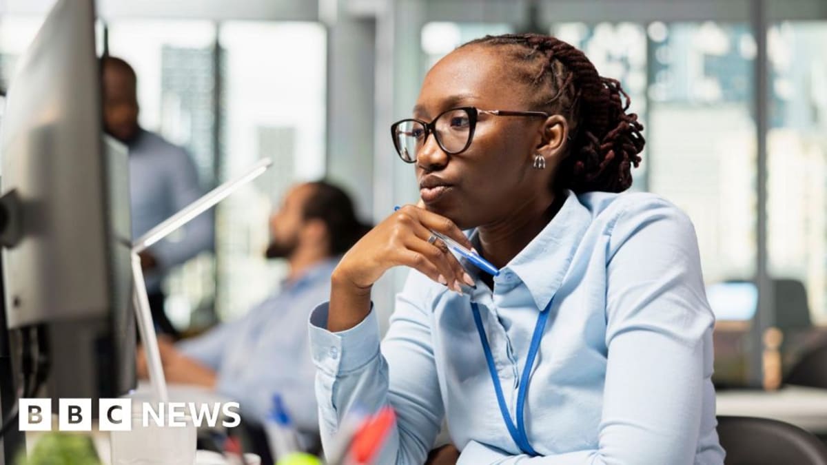 Office workers collaborating happily in modern workplace with technology displays visible