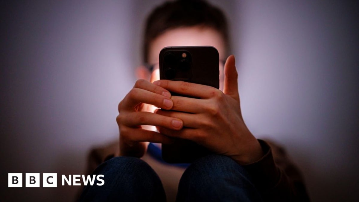 Young person holding smartphone with parental safety features protecting their digital experience