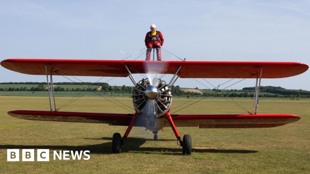 98-year-old Harry Heasman strapped to top of vintage biplane during record-breaking wing walk