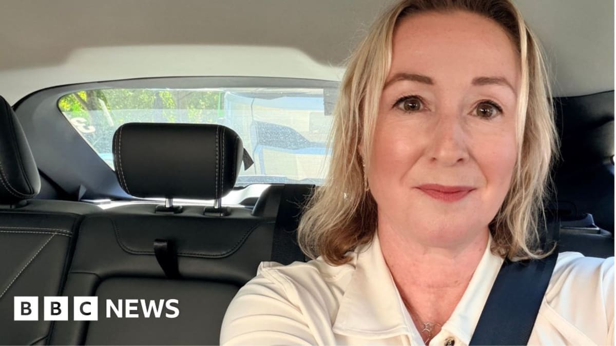 Interior view from self-driving Uber taxi navigating busy London street with safety driver present