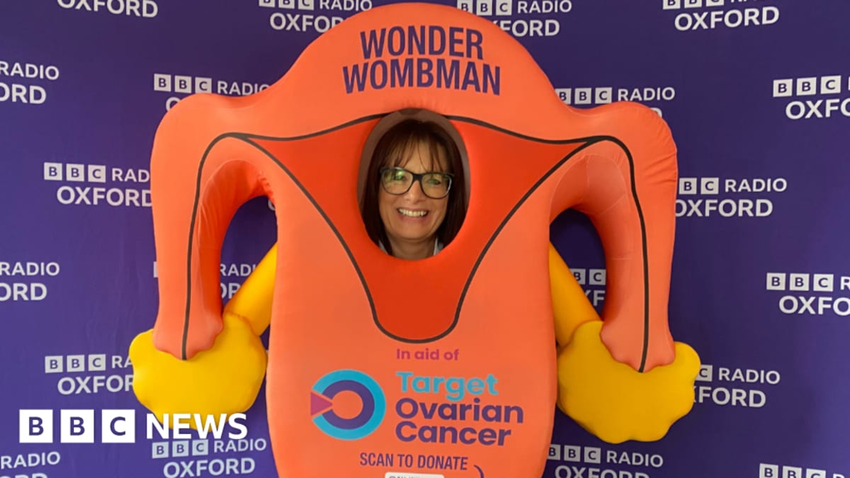 Runner Lisa Hale wearing large pink ovaries costume at London half marathon finish line