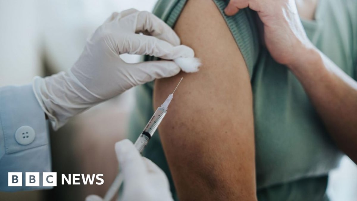 Medical researchers examining vaccine vials in laboratory conducting cancer treatment breakthrough research