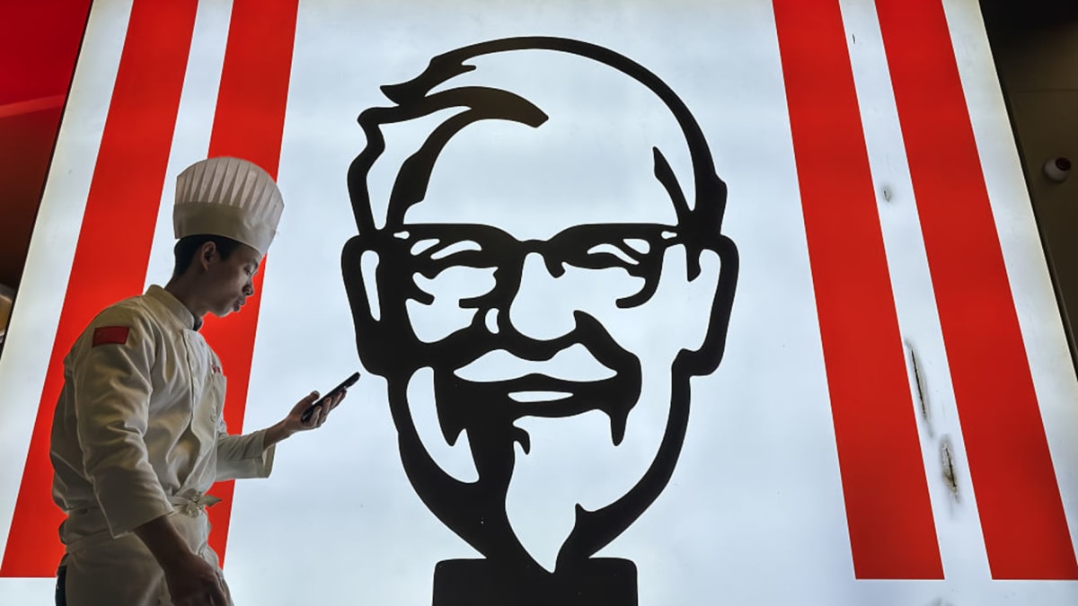** Illuminated KFC restaurant sign glowing at night in Chongqing, China, representing fast-food charging partnership