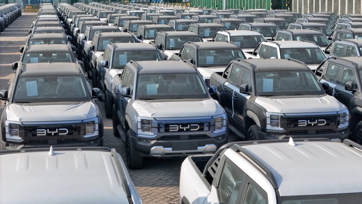 Modern Chinese electric vehicle on display at auto show with interested dealers examining features