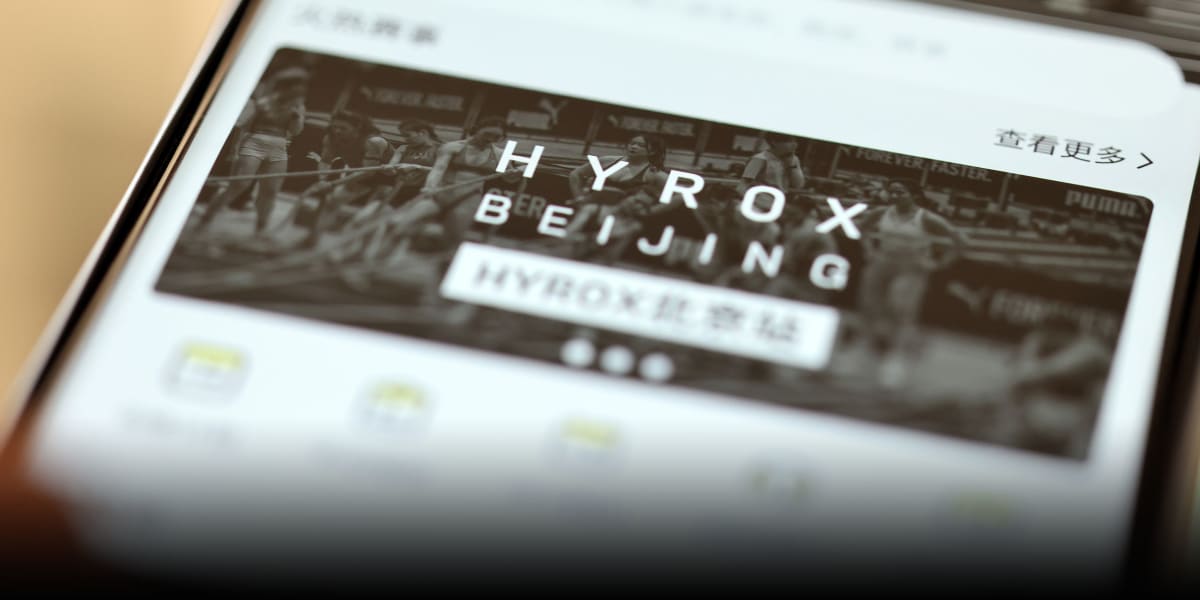 Athletes competing in Hyrox fitness competition combining running and strength training stations