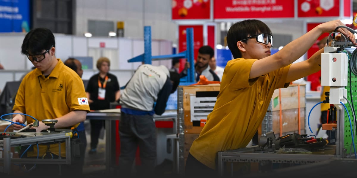 Young competitors preparing robotic equipment at WorldSkills Competition workshop in Shanghai