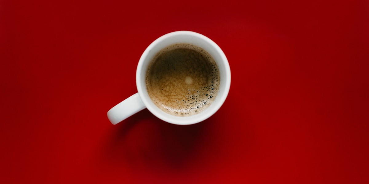 Traditional Italian coffee bar interior with espresso machine and customers gathering at counter