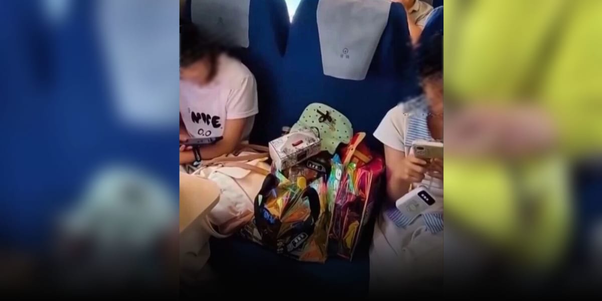 Empty train seat beside two teenage girls with luggage during long-distance journey