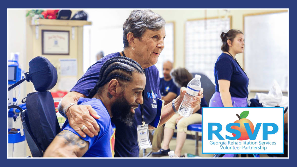Volunteer encourages patient during wheelchair rehabilitation therapy session at Atlanta medical center