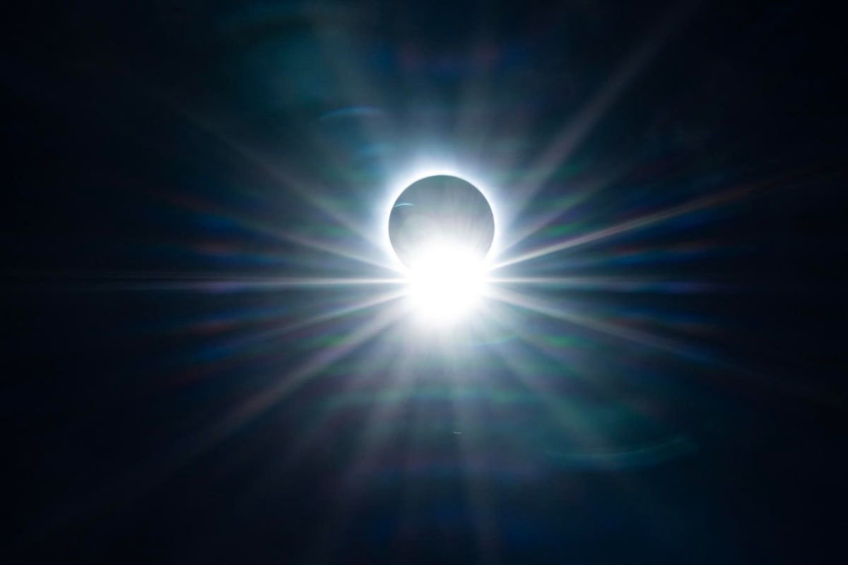 Total solar eclipse showing sun's corona glowing around moon's dark silhouette against black sky
