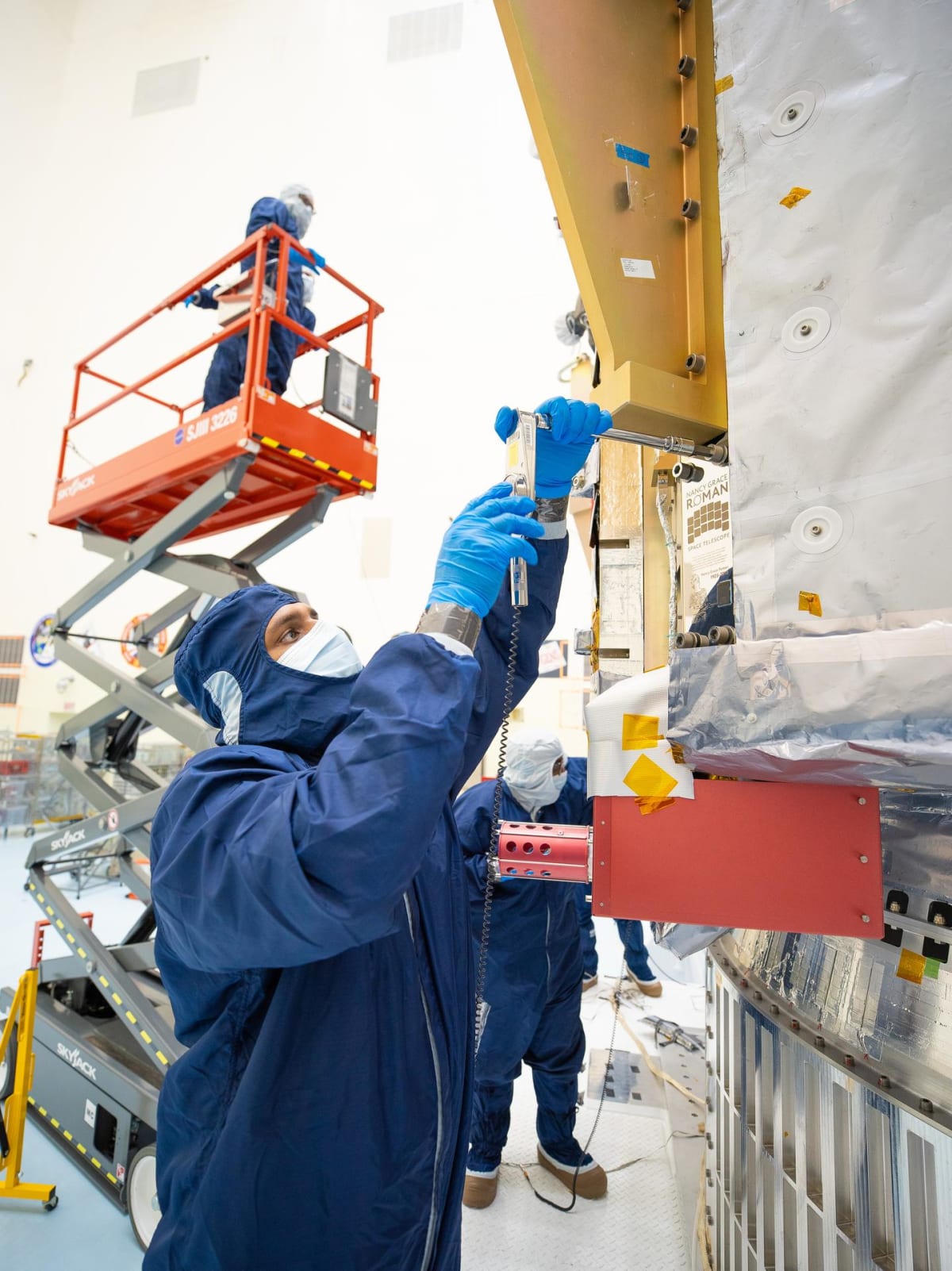 NASA technicians install commemorative plaque with memory card onto Roman Space Telescope at Kennedy Space Center