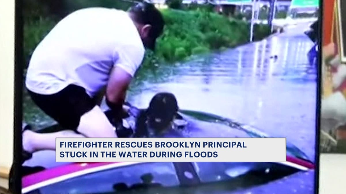 Off-duty firefighter standing on submerged car roof rescuing trapped woman through sunroof during Brooklyn flood