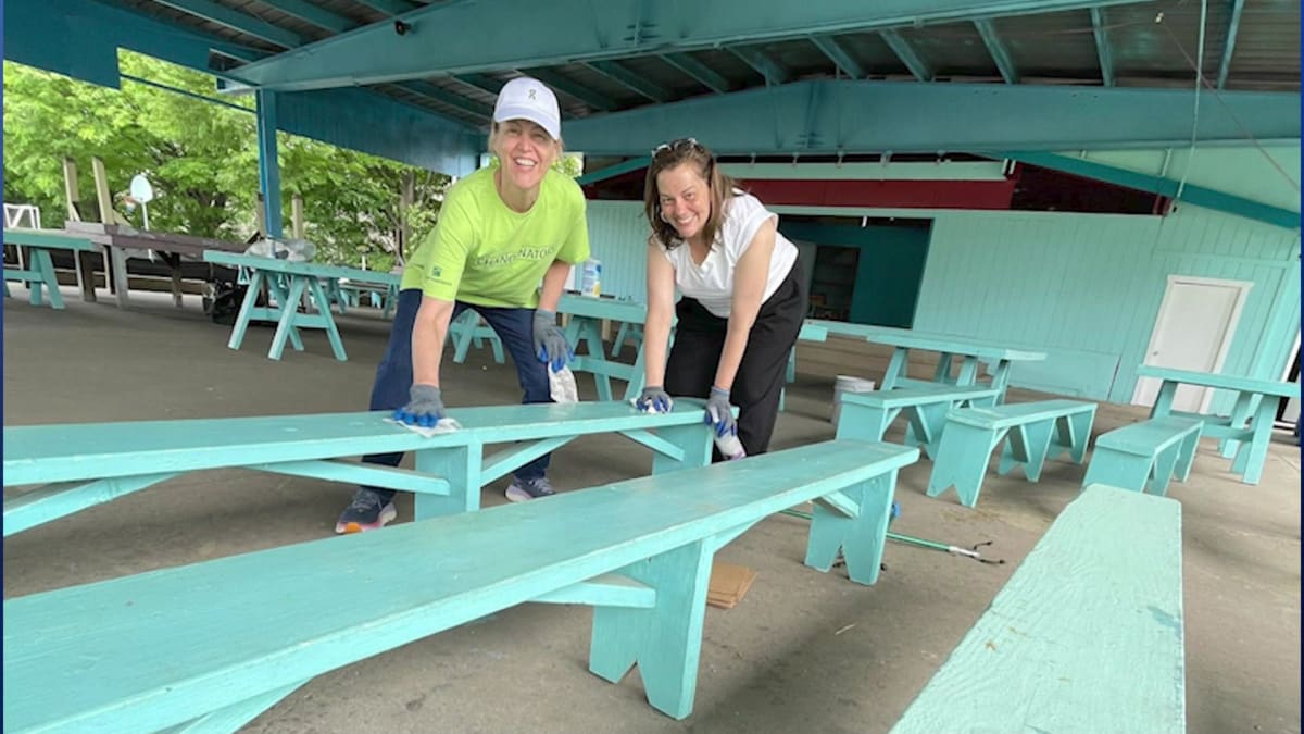 Volunteers painting picnic tables and cleaning outdoor facilities at Camp Liberty in Liberty State Park