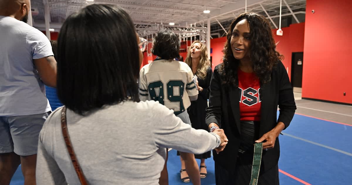 ** Dominique Dawes holding her 1996 Olympic gold medal at new Alpharetta gymnastics academy opening