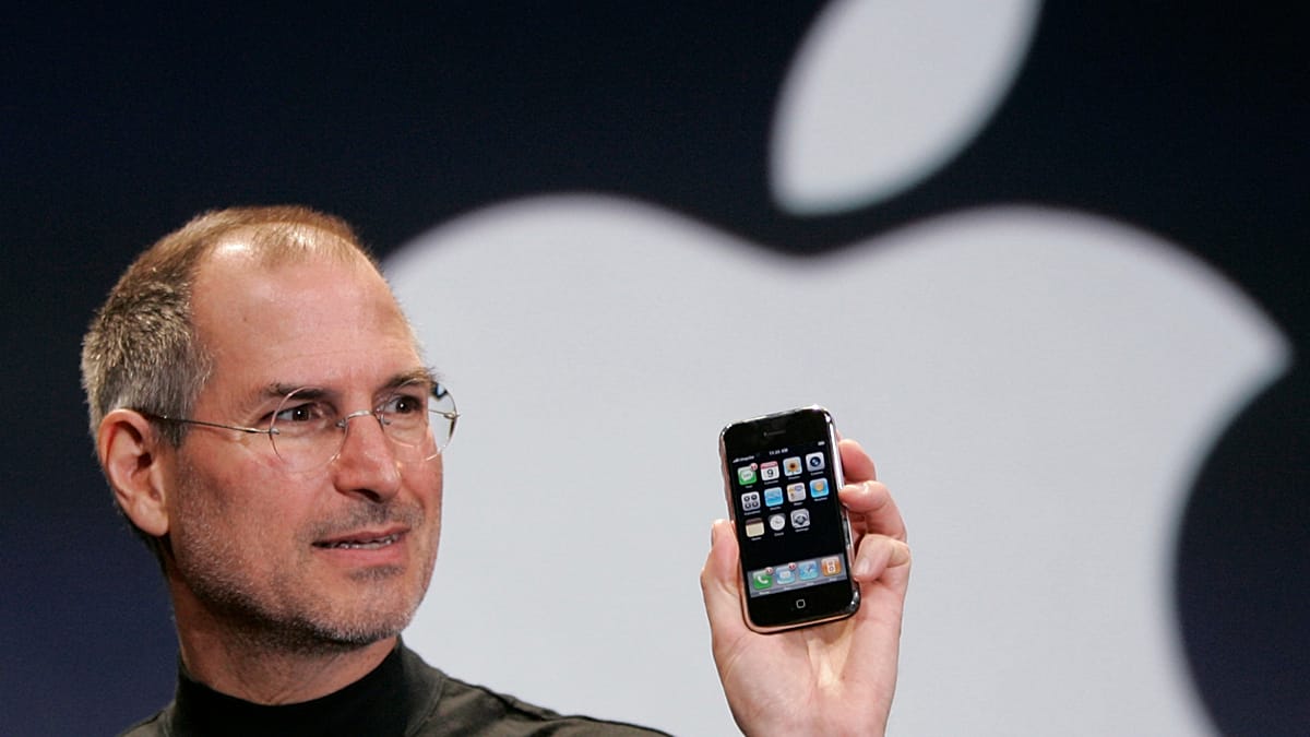 Steve Jobs presenting Apple products at company event showcasing innovative technology design
