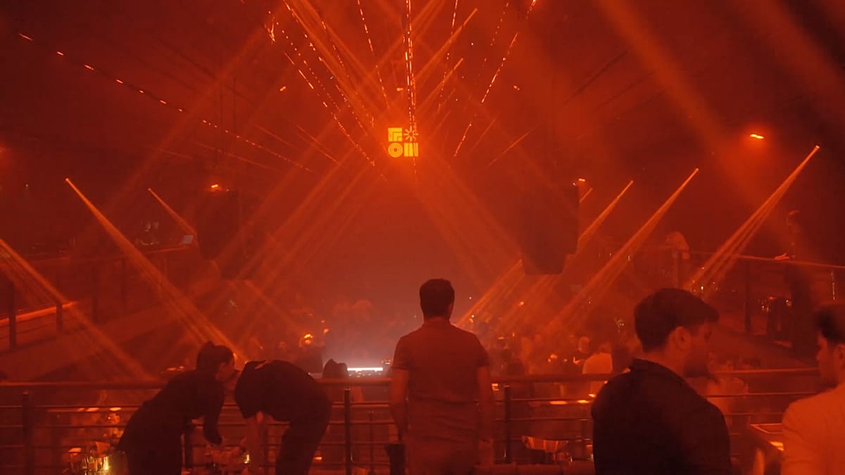 Young DJ performing at electronic music event in Baku, Azerbaijan with crowd dancing