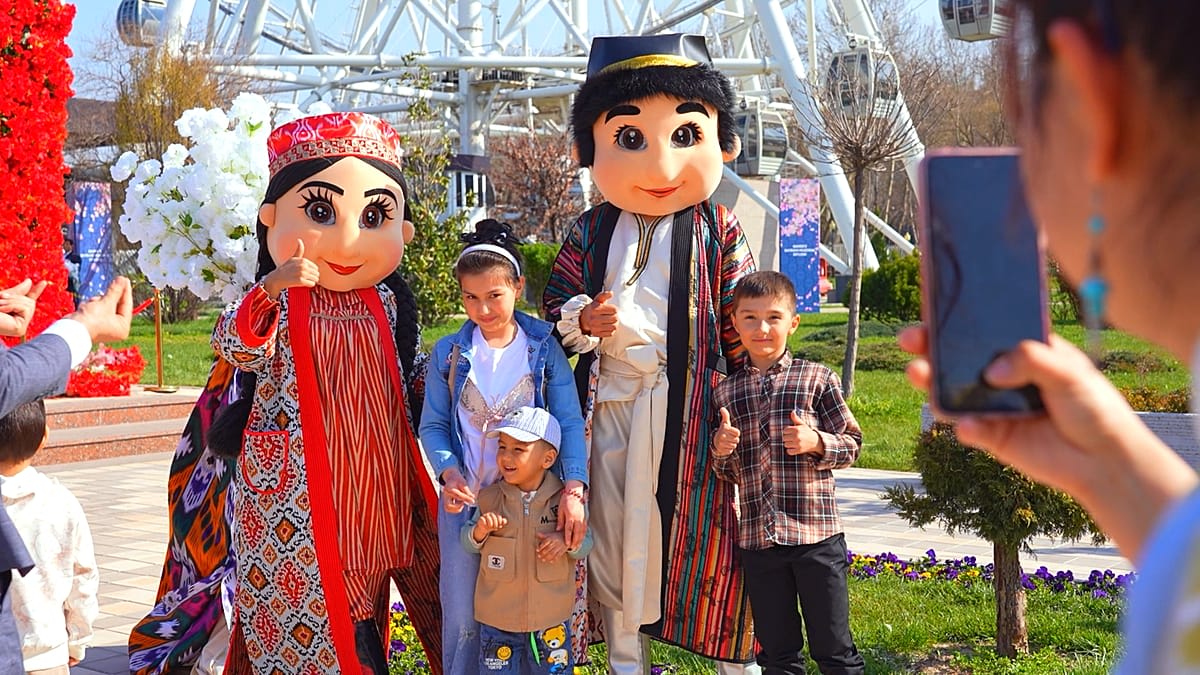** Large crowd celebrating Nowruz spring festival in Uzbekistan with traditional food and performances