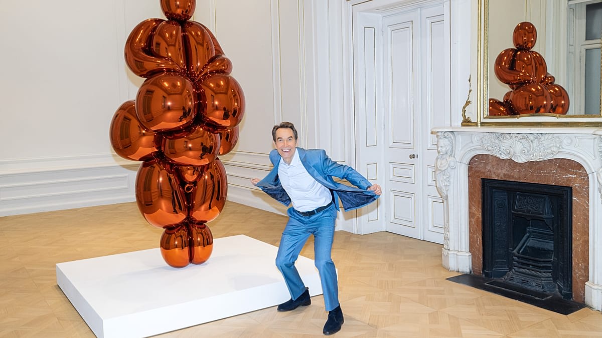 ** Shiny orange balloon-like steel sculpture by Jeff Koons in museum gallery setting