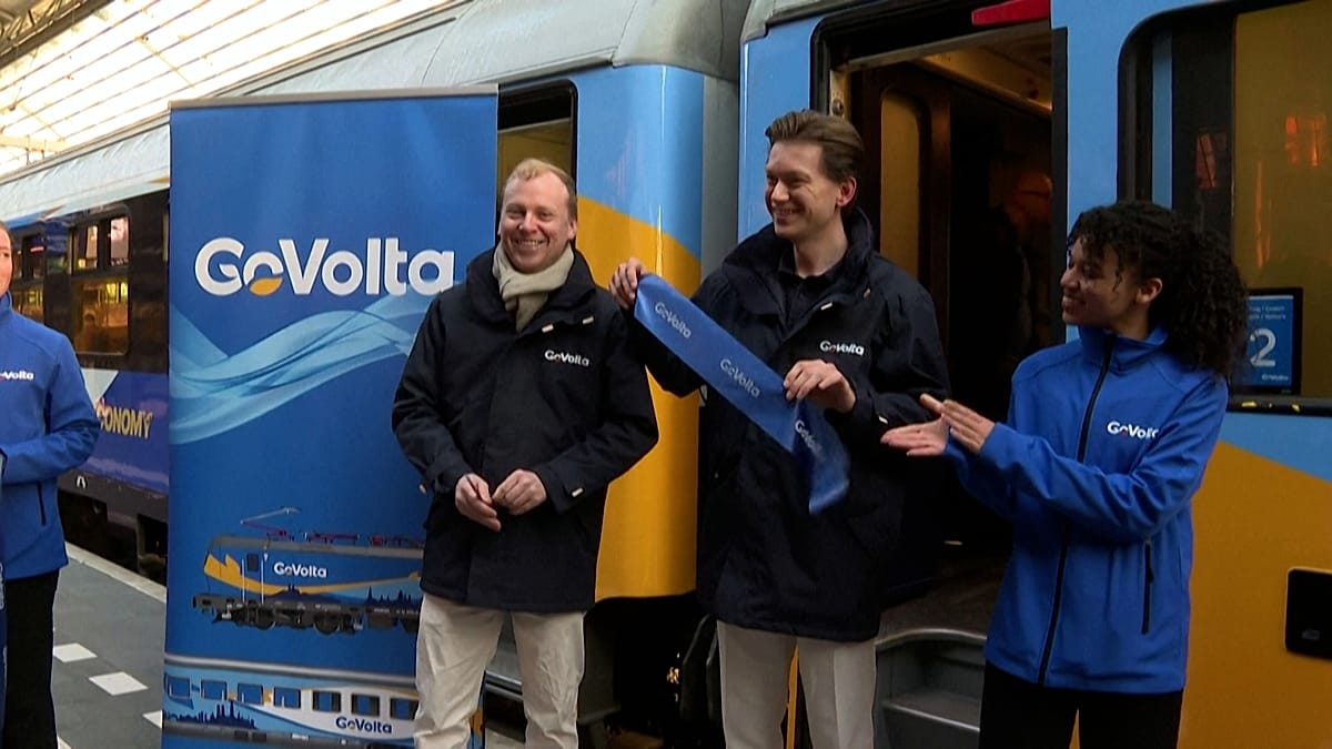 Modern passenger train departing Amsterdam Centraal station on inaugural GoVolta budget rail service to Berlin