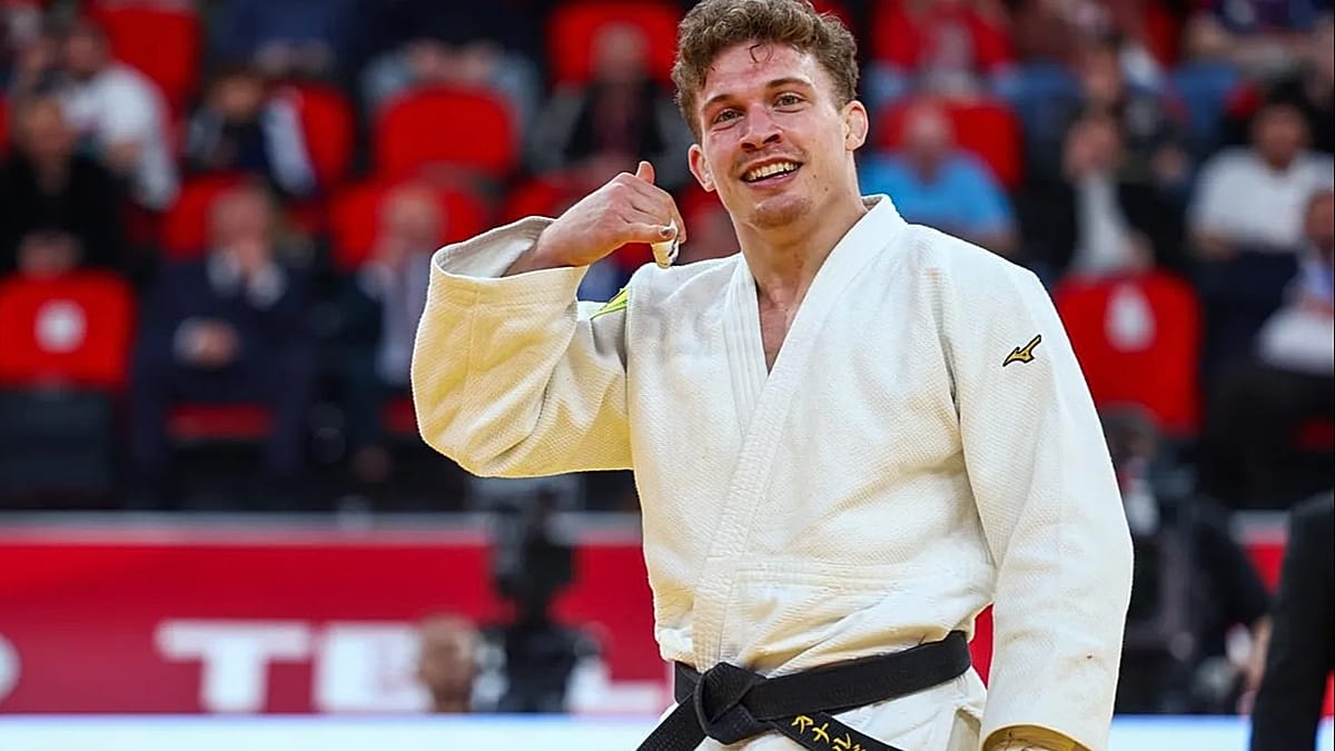 Judoka celebrates on mat with arms raised after winning gold medal at Tbilisi Grand Slam