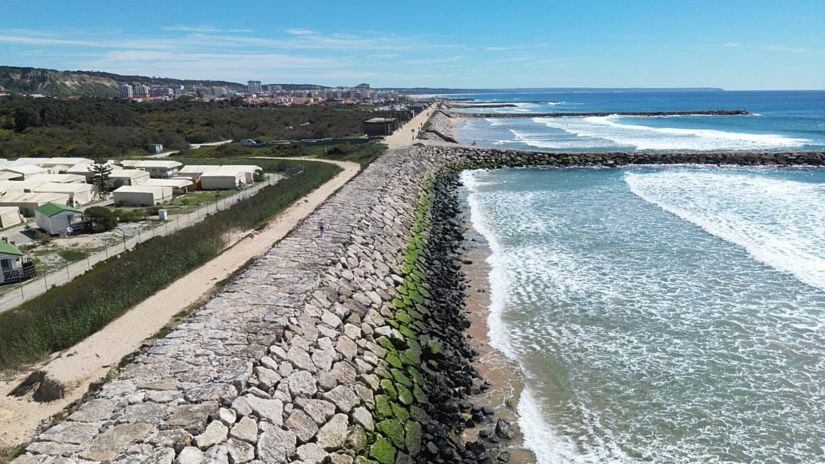 Restored sand dunes on Portuguese beach protecting coastline from ocean waves and erosion
